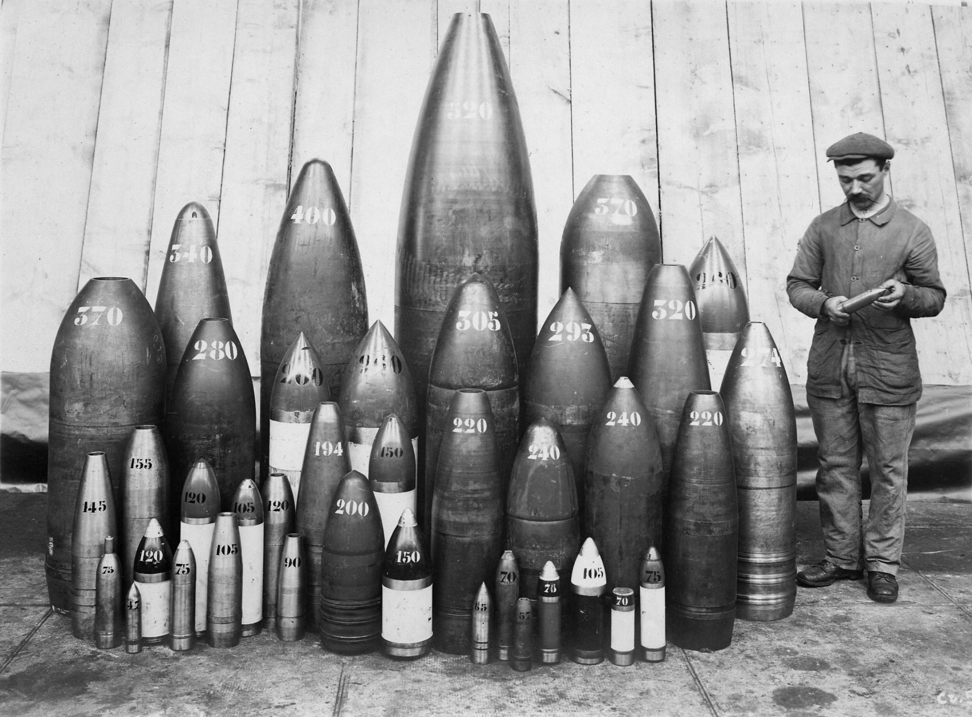 Artillerie Le Creusot. Ouvrier posant devant un ensemble d'obus. 1916. Collection AFB.